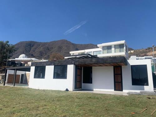 a white house with a mountain in the background at Villa Baruch in San Juan Cosalá