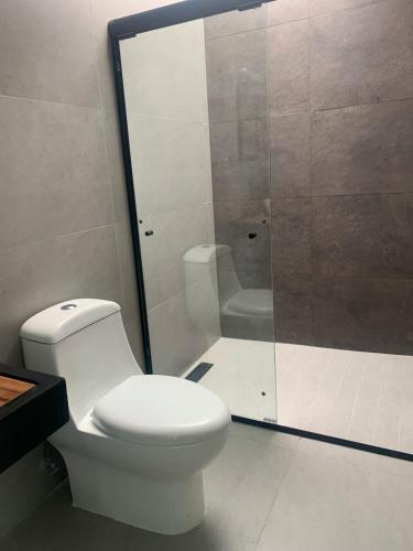 a bathroom with a toilet and a glass shower at Villa Baruch in San Juan Cosalá