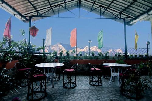 een patio met tafels, stoelen en vlaggen bij Central Hill Resort The Mall Road in Gangtok