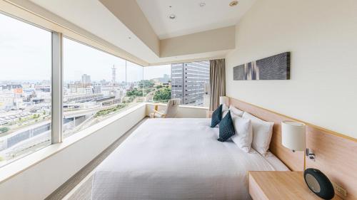 um quarto com uma cama e uma grande janela em Fraser Residence Nankai Osaka em Osaka