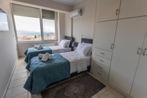 two beds in a bedroom with a view of the ocean at ΑμφιΘΕΑ! στη ΝΑΥΠΑΚΤΟ ! in Nafpaktos