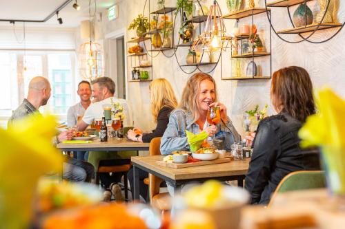 un gruppo di persone seduti ai tavoli in un ristorante di De Maasparel Nextdoor Maassuites ad Arcen