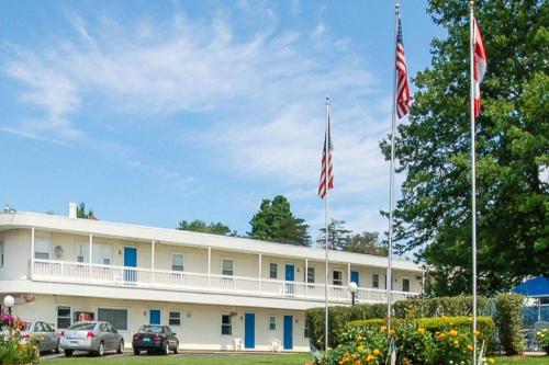 two american flags flying in front of a building at Rodeway Inn in Rutland