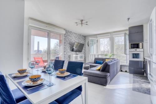 a kitchen and living room with a table and chairs at "Le Sérénity ", Appartement spacieux ,balcon, parking privé gratuit, proche CDG et Stade de France in Stains