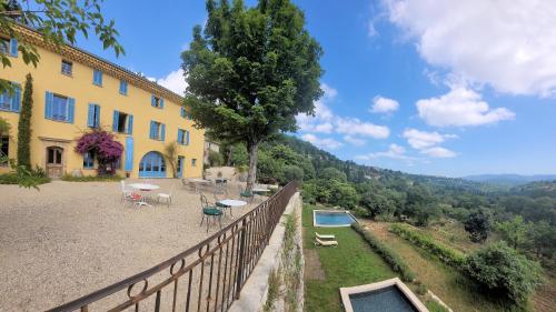 ein Haus mit einem Zaun neben einem Pool in der Unterkunft Domaine de la Cascade Parfumée in Grasse