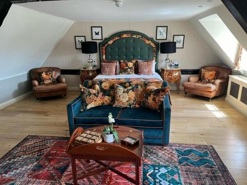 a bedroom with a bed and a couch and a table at The White Horse Hotel, Romsey, Hampshire in Romsey