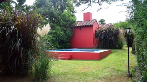 un edificio rosso con piscina in un cortile di Pirpintos, Cabanas de San Lorenzo a San Lorenzo