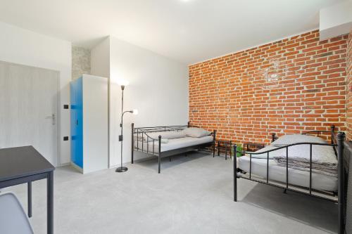 オストラヴァにあるHostel na Šalamouněのレンガの壁、ベッド2台が備わる客室です。