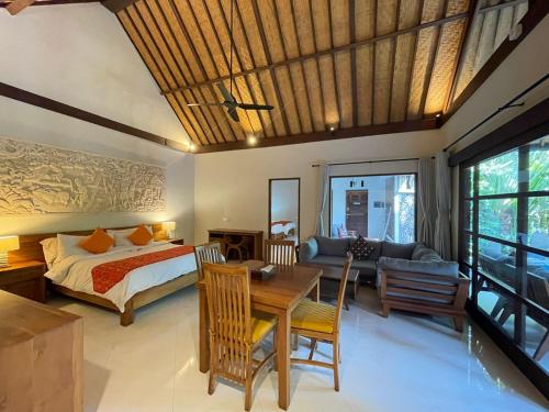 1 dormitorio con cama, mesa y sofá en Bali Santi Bungalows, en Candidasa