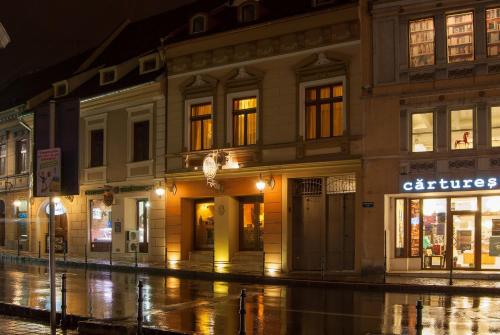 een gebouw in een stadsstraat 's nachts bij Hotel Bella Muzica in Braşov