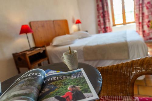 - une table avec un livre, un magazine et une bougie dans l'établissement Maison d'Hôtes Mas de la Chadenede, à Lagorce