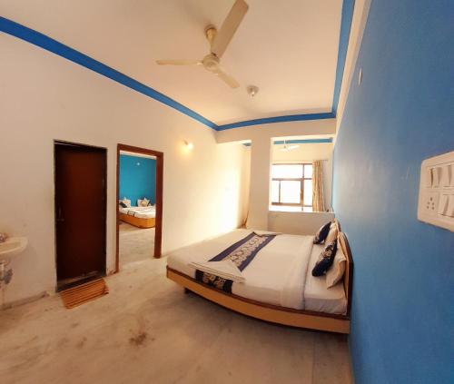 een slaapkamer met een bed met blauwe muren en een plafond bij Hotel Indore Palace - Guest Centric Hotel in Shirdi