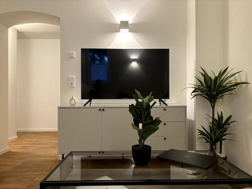 uma sala de estar com uma televisão de ecrã plano na parede em City Apartment am Fluss em Frankfurt am Main