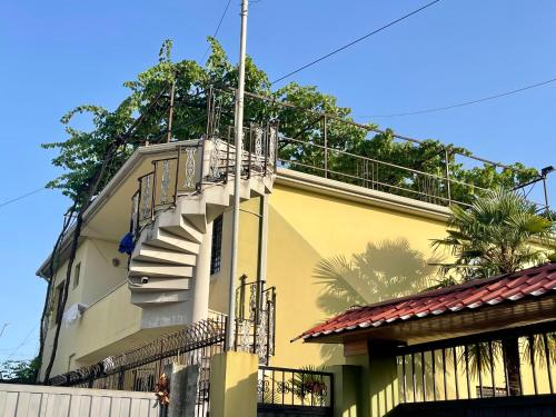 ein gelbes Gebäude mit einer Seitentreppe in der Unterkunft Xhou's Home in Shkodra