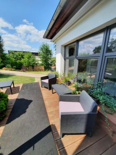 un patio avec des chaises et des tables sur une terrasse en bois dans l'établissement Vincent, à Luhačovice