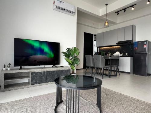 Urban Suites TWO Or THREE Bedroom Georgetown by ANC في Jelutong: غرفة معيشة مع تلفزيون بشاشة مسطحة كبيرة على جدار