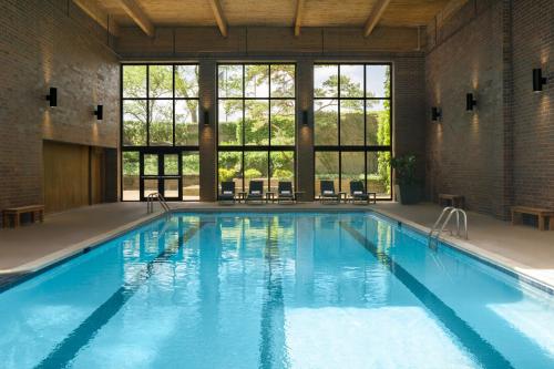 a large pool with blue water in a building with windows at The Westin Chicago Northwest in Itasca