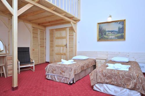 une chambre d'hôtel avec deux lits et une chaise dans l'établissement Pensjonat Stańczyk, à Cracovie