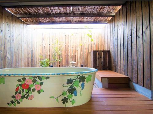 La salle de bains est pourvue d'une baignoire ornée de fleurs. dans l'établissement Hostel OSAKA, à Osaka