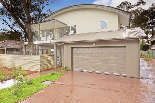 una casa grande con un garaje delante en The Beach Townhouse, en Hawks Nest