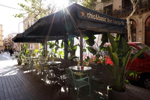 un café en plein air avec des tables et des chaises sous un parasol dans l'établissement Chic & Basic Born Boutique Hotel, à Barcelone