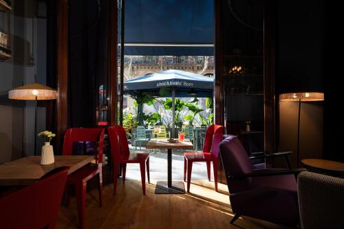 un restaurant avec une table, des chaises et un parasol dans l'établissement Chic & Basic Born Boutique Hotel, à Barcelone