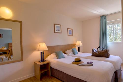 Cette chambre comprend 2 lits et un miroir. dans l'établissement Residence Reine Marine, à Saint-Malo