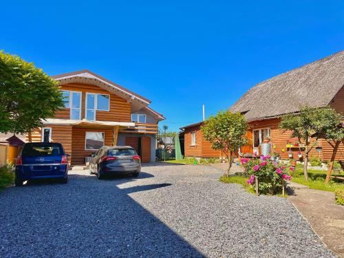 a house with two cars parked in the driveway at Три-О Апартаменти з балконом, без сусідів за стінкою, для 2-4 осіб in Slavske