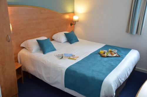 een hotelkamer met een bed en een dienblad met eten erop bij BRIT HOTEL Caen Hérouville in Hérouville-Saint-Clair