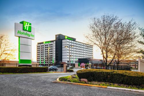 Holiday Inn Newark International Airport في نيوآرك: مبنى امامه لوحة هيلتون