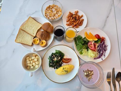 une table blanche avec des assiettes de nourriture dans l'établissement Sotetsu Hotels The Splaisir Seoul Dongdaemun, à Séoul