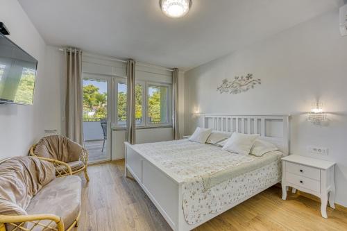 um quarto branco com uma cama e uma cadeira em Jozefina Luxury, 100 m from the beach em Poreč