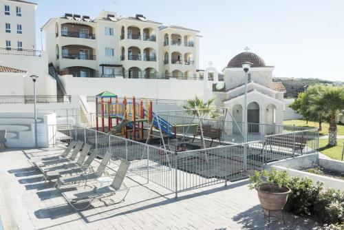 un parque infantil frente a un edificio en Club St. George, en Pafos