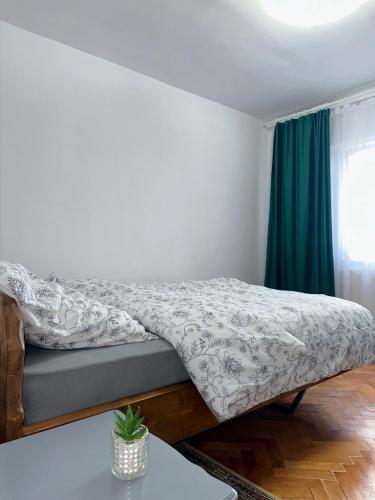 a bed in a bedroom with a green curtain at B7 Apartament in Ocna-Mureşului