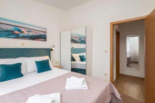 a bedroom with a large bed with blue pillows at La Playa Beach Apartment in Omiš