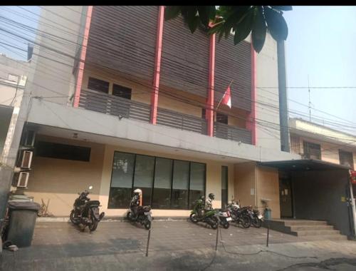 een groep motorfietsen geparkeerd buiten een gebouw bij Guest House Permata Tawakal in Jakarta