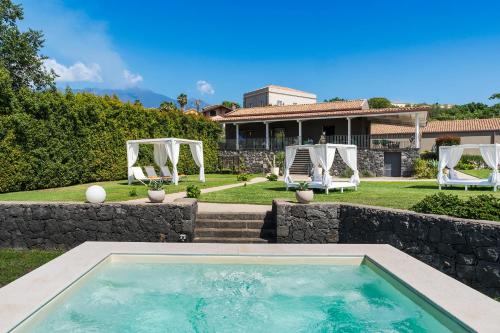 una piscina en el patio trasero de una casa en Kepos Etna Relais & Exclusive Spa, en Santa Venerina