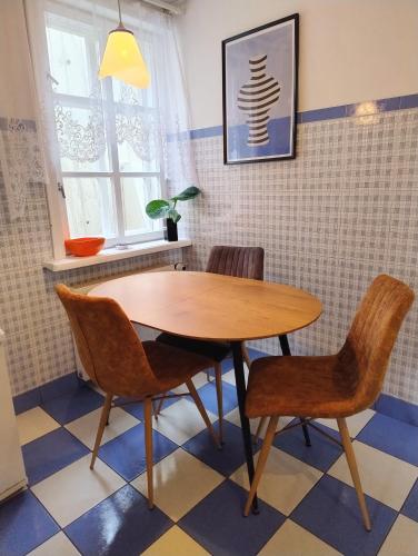 een houten tafel en stoelen in een kamer bij GreenHill House in Kaunas