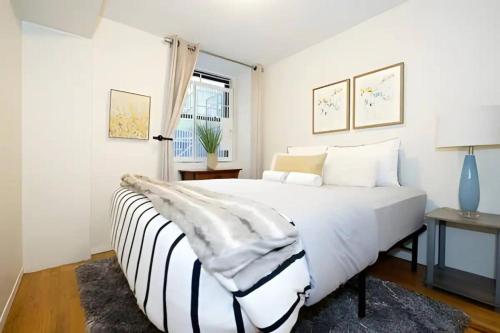 纽约For Rent in Chelsea Your Ideal Space Awaits l Cardi l的白色的卧室设有一张大床和一个窗户