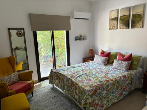 una camera con un letto e una sedia e una finestra di Bay Cottage Beautiful cosy luxury cottage - Beach area a Pissouri