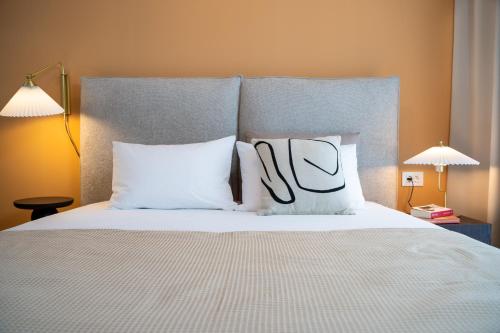 - un lit avec des oreillers blancs dans l'établissement Cityscape Luxe, Modern & Cozy Apartment, à Braşov