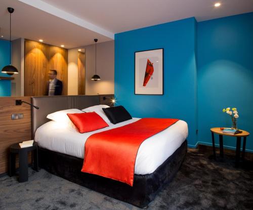 a hotel room with a large bed with a red blanket at Hostellerie Du Chapeau Rouge in Dijon