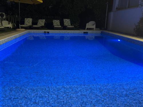 una gran piscina azul por la noche en Ria Studios, en Olhão