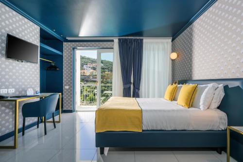 una camera blu con letto e scrivania di Hotel Mary a Vico Equense