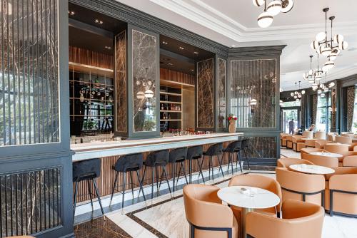 a restaurant with a bar with tables and chairs at Hotel Balkan in Belgrade