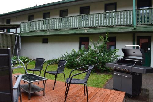 a patio with chairs and a grill on a deck at Guesthouse & sauna by HMTL in Liepāja