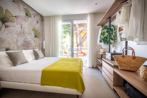 a bedroom with a bed with a yellow blanket on it at Residence Lido di Dante in Lido di Jesolo