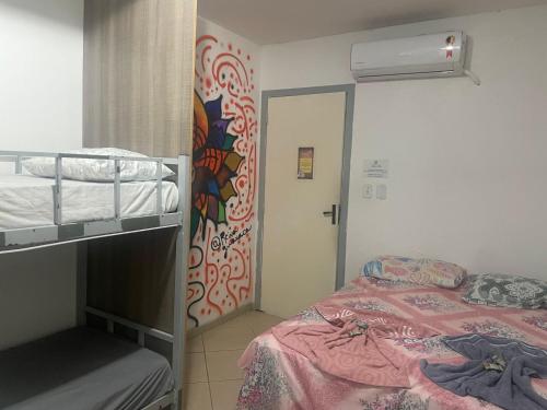 sypialnia z łóżkiem piętrowym i ścianą z malowidłem ściennym w obiekcie Soul do Mar Hostel w mieście Cabo Frio