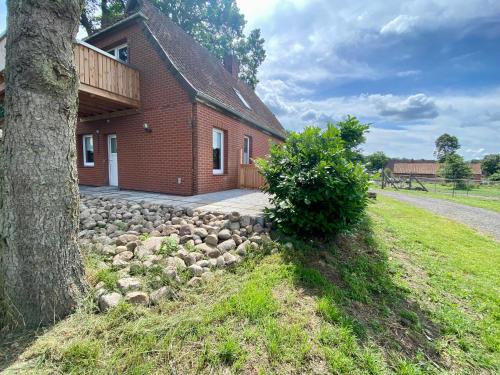 ein Backsteinhaus mit einem Baum davor in der Unterkunft Ferienwohnung Straußenblick Dachgeschoss in Bad Fallingbostel