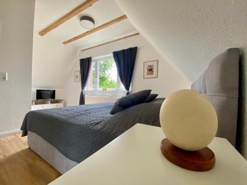 ein Schlafzimmer mit einem Bett und einem Tisch mit einem Stuhl in der Unterkunft Ferienwohnung Straußenblick Dachgeschoss in Bad Fallingbostel